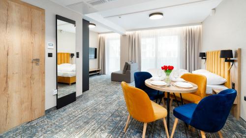 - une chambre d'hôtel avec une table et des chaises dans l'établissement Apartamenty Sun & Snow Złoty Horyzont, à Szklarska Poręba