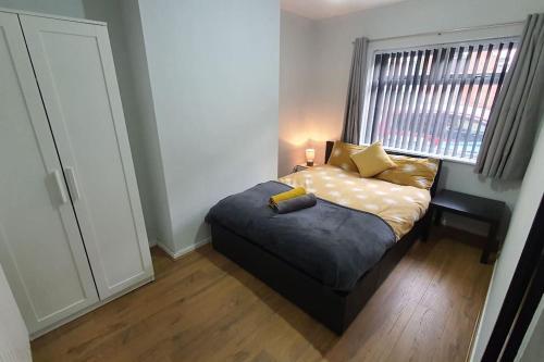 a bedroom with a bed and a window at Contractors-City Centre-Parking-Sleeps 9 -Smart TV, 2 Toilets! in Coventry