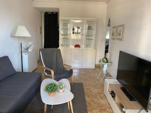 a living room with a couch and a tv at Lovely bungalow with two big terrasses in Orihuela