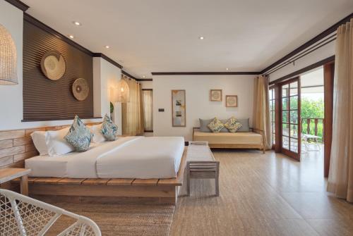 una camera da letto con un grande letto bianco e un tavolo di Hotel L'Archipel a Baie Sainte Anne