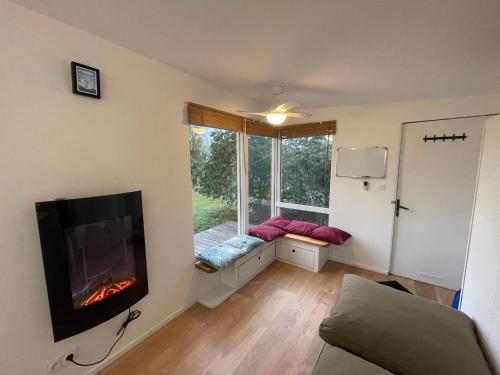 a living room with a fireplace and a window at Domaine La Tour in Loubens