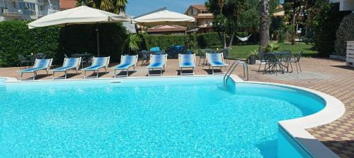 a swimming pool with blue chairs and umbrellas at Hotel Marinella in Pizzo