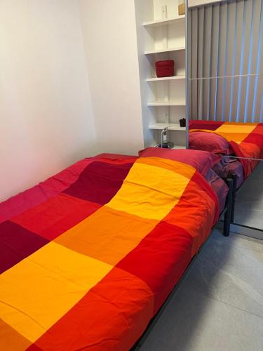 - une chambre avec 2 lits recouverts d'une couverture colorée dans l'établissement Antibes carré d'or Bastion Albert 1er Vue mer, à Antibes