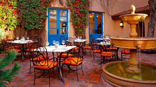 een binnenplaats met tafels en stoelen en een fontein bij Hotel St Francis in Santa Fe