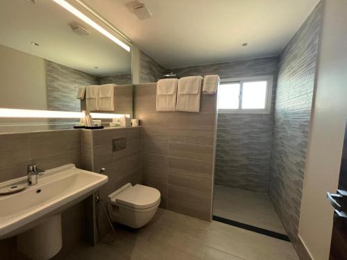 a bathroom with a toilet and a sink and a shower at Nordic Gardens in Manama