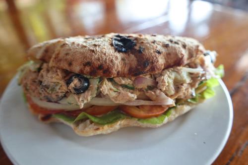 a sandwich on a white plate on a table at Ziggy Stardust in Ko Phayam