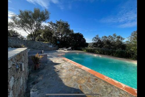- une piscine dans une cour dotée d'un mur en pierre dans l'établissement Maison Jardin d'Agrumes - Lozari, à Belgodère