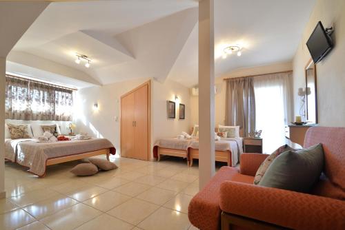 um quarto de hotel com duas camas e um sofá em Εlvina apartments em Leptokarya