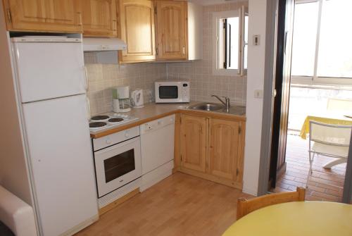 uma cozinha com electrodomésticos brancos e armários de madeira em ETOILE DES NEIGES em Orcières