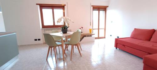 a living room with a table and chairs and a red couch at Casa Pereira in Rome