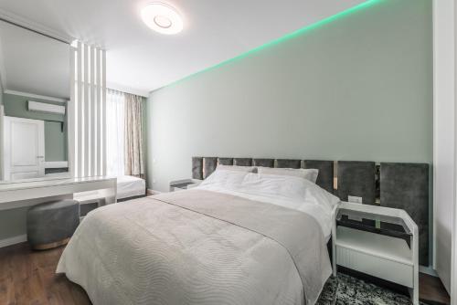 a bedroom with a large bed and a mirror at Sky Apartments in Durrës