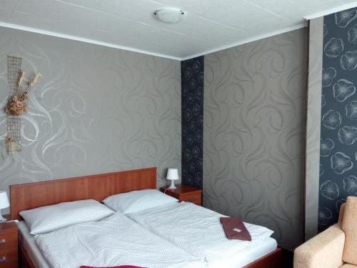 - une chambre avec un lit dans une pièce avec un mur dans l'établissement Hotel Koliba, à Vrbno pod Pradědem