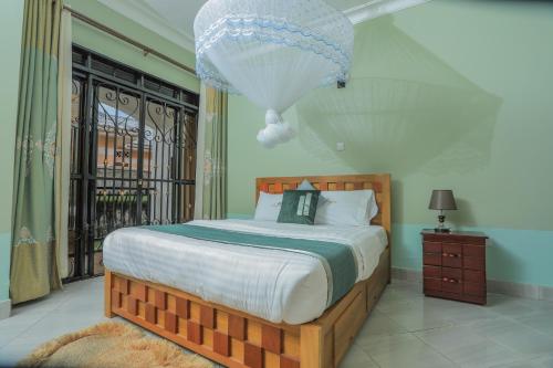 a bedroom with a bed and a window with a chandelier at Fort Suites in Fort Portal