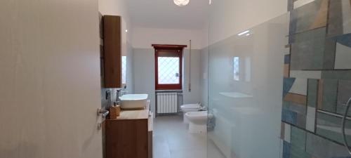 a bathroom with two toilets and a sink and a window at Casa Pereira in Rome