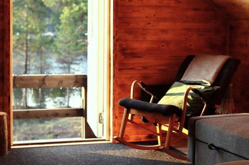a rocking chair in a room with a window at Cozy Cabin Styled Loft in Kiruna