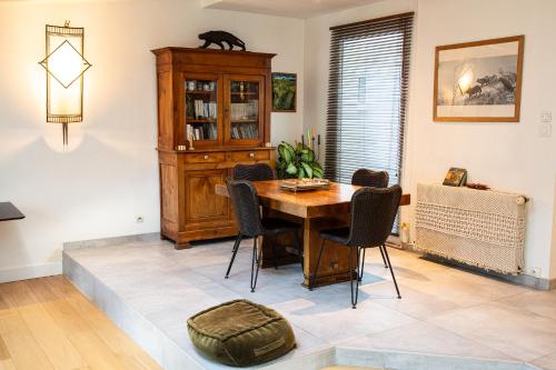 a dining room with a table and a cat on top at Le nid du massereau in Bouguenais