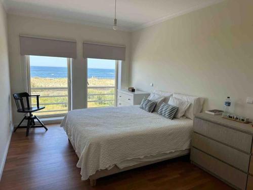 um quarto com uma cama e vista para o oceano em Apartamento vista mar em Labruge