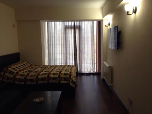 una camera d'albergo con letto e finestra di New Gudauri Apartment a Gudauri