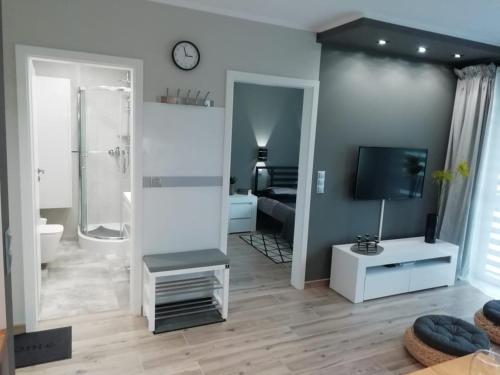 a living room with a television and a bathroom at Apartamenty u Nataszy in Ustrzyki Dolne