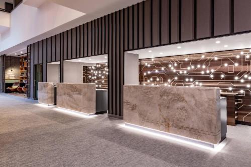 a lobby with two reception desks and a wall with lights at Stuttgart Marriott Hotel Sindelfingen in Sindelfingen