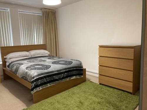 um quarto com uma cama, uma cómoda e um tapete verde em Jacoby Place em Birmingham