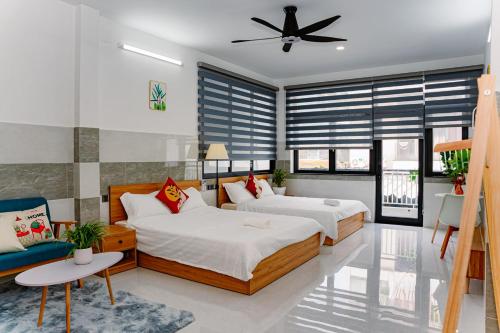 a bedroom with two beds and a ceiling fan at ALOHA SAIGON PREMIUM HOSTEL by Local Travel Experts - Newly opened, Less-touristy location, Spacious rooms, Glass shower bathroom, Free breakfast & Walking Tour in Ho Chi Minh City