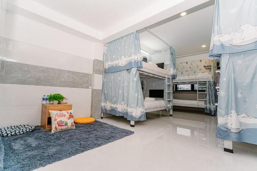 a bedroom with two bunk beds with blue curtains at ALOHA SAIGON PREMIUM HOSTEL by Local Travel Experts - Newly opened, Less-touristy location, Spacious rooms, Glass shower bathroom, Free breakfast & Walking Tour in Ho Chi Minh City