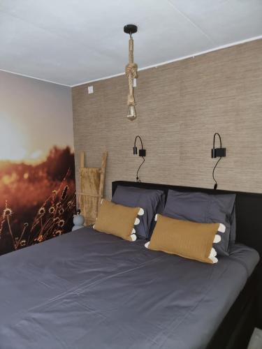 a bedroom with a blue bed with two pillows at Logeren bij Sabine en JW in Beekbergen