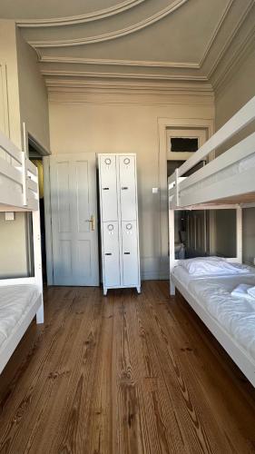 a room with two bunk beds and a wooden floor at A Beira Hostel in Aveiro