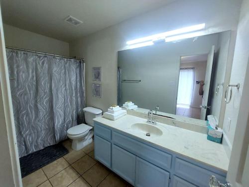 een badkamer met een wastafel, een toilet en een spiegel bij Luxury living in 2 beds 2 baths near Fort Cavazos in Killeen