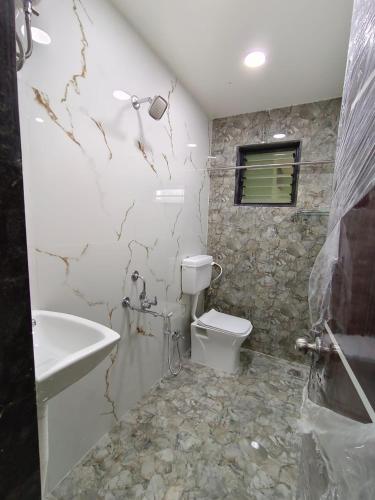ein Badezimmer mit einem weißen WC und einem Waschbecken in der Unterkunft Agrawal Stay Viman Nagar (Female Only) in Pune