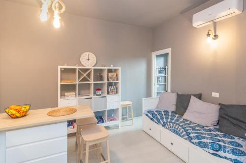 Kleines Zimmer mit einem Bett und einem Schreibtisch mit einer Uhr in der Unterkunft White Sand House in Marina di Portisco