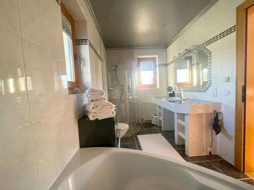 een witte badkamer met een bad en een wastafel bij Ferienhaus Hildegard in Kössen