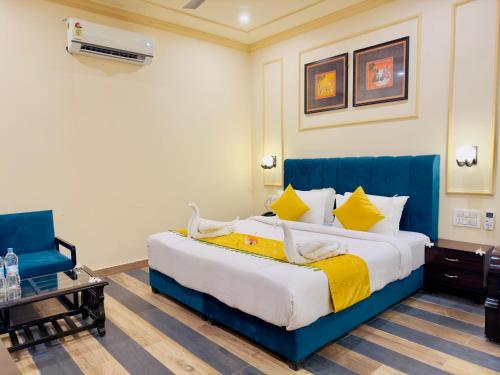 a bedroom with a large bed with a blue headboard at Udai Valley Resort- Top Rated Resort in Udaipur with mountain view in Udaipur