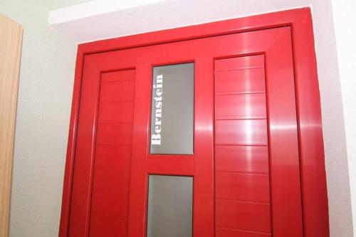 une porte rouge avec un panneau sur elle dans l'établissement Bernstein, à Poreč