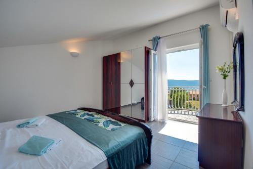 een slaapkamer met een bed en een deur naar een balkon bij Villa Dada in Linardići