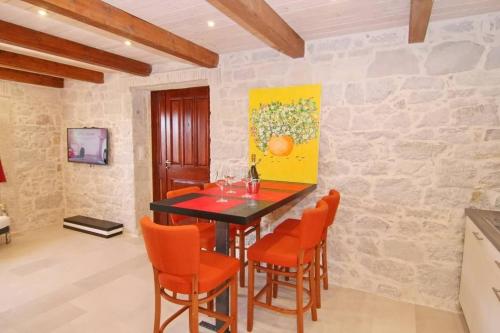- une salle à manger avec une table et des chaises orange dans l'établissement Casa Ladonia, à Poreč