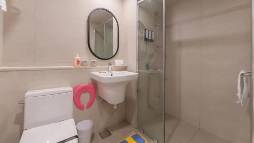 a bathroom with a sink and a shower with a mirror at Geoje Mongdol Beach H Avenue Hotel in Geoje 