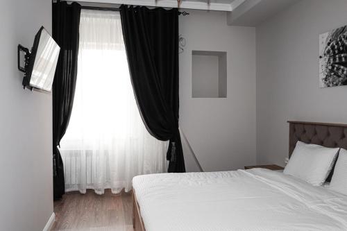 a bedroom with a bed and a window at Deluxe Park Z hotel in Almaty