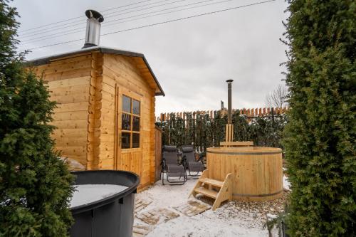 a wooden cabin with a hot tub in the yard at Wellness Apartmány Vila Republika in Velké Losiny