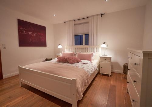 a bedroom with a bed with pink pillows and a window at Ferienwohnung Vierländereck nahe Winterberg in Elpe