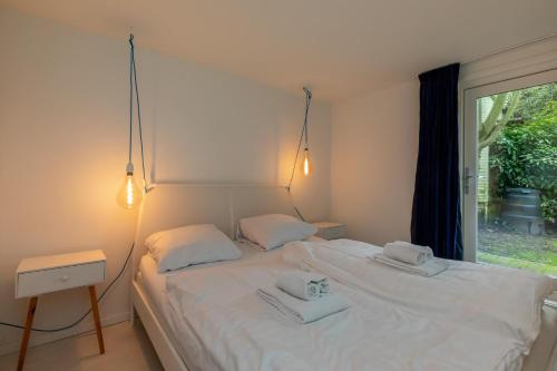 1 dormitorio con 1 cama con 2 toallas en Vakantiewoning - Valkenisseweg 68 l Biggekerke 'Strand Bungalow', en Biggekerke
