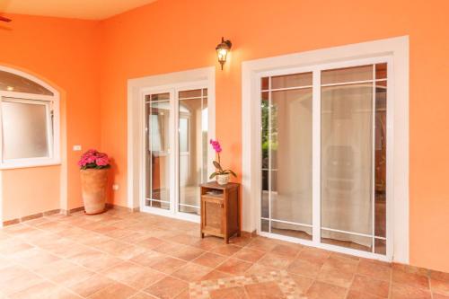 orangefarbenes Zimmer mit Glastüren und Fliesenboden in der Unterkunft Villa Brioni 1 in Pula