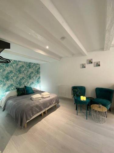 - une chambre avec un lit et deux chaises vertes dans l'établissement Esprit Jungle ........ au coeur de Mulhouse, à Mulhouse