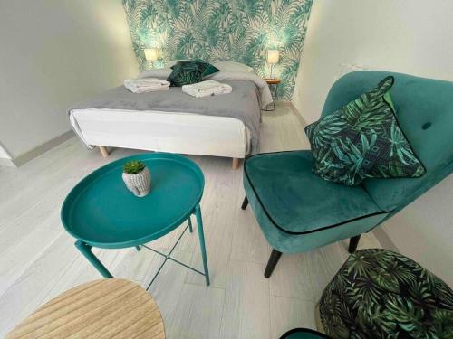 1 dormitorio con 1 cama, 1 mesa y 1 silla en Esprit Jungle ........ au coeur de Mulhouse, en Mulhouse