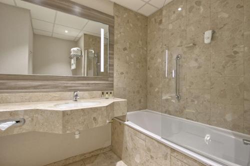 y baño con lavabo, bañera y espejo. en Best Western Plus Paris Orly Airport, en Rungis
