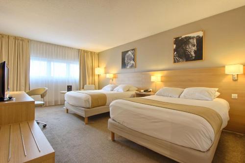 a hotel room with two beds and a television at Best Western Plus Paris Orly Airport in Rungis
