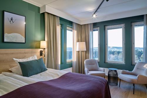 ファールンにあるScandic Lugnetのベッド1台、椅子、窓が備わる客室です。