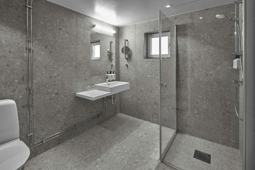 uma casa de banho com um lavatório e um chuveiro em Scandic Lugnet em Falun