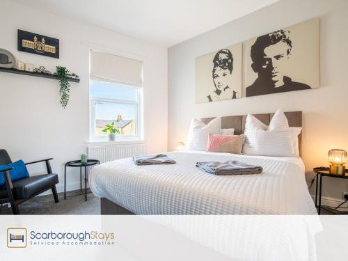 スカーバラにあるHampton House - Lovely and Spacious 2 Bedroom Apartment - WITH FREE PARKINGの白いベッドルーム(ベッド1台、椅子付)